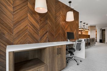 a room with a long desk with a computer on it and a wooden wall behind it